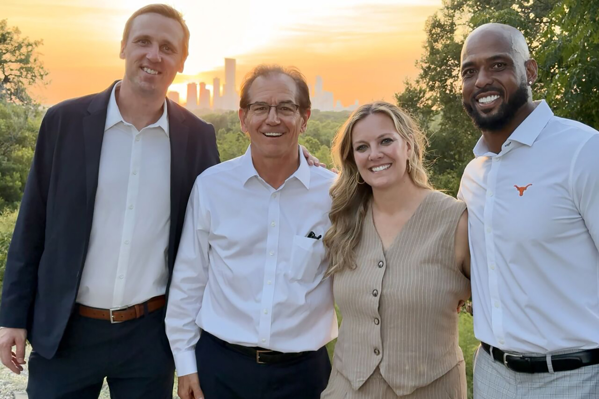 Four guests together on the bluff at sunset with the Austin skyline behind them
