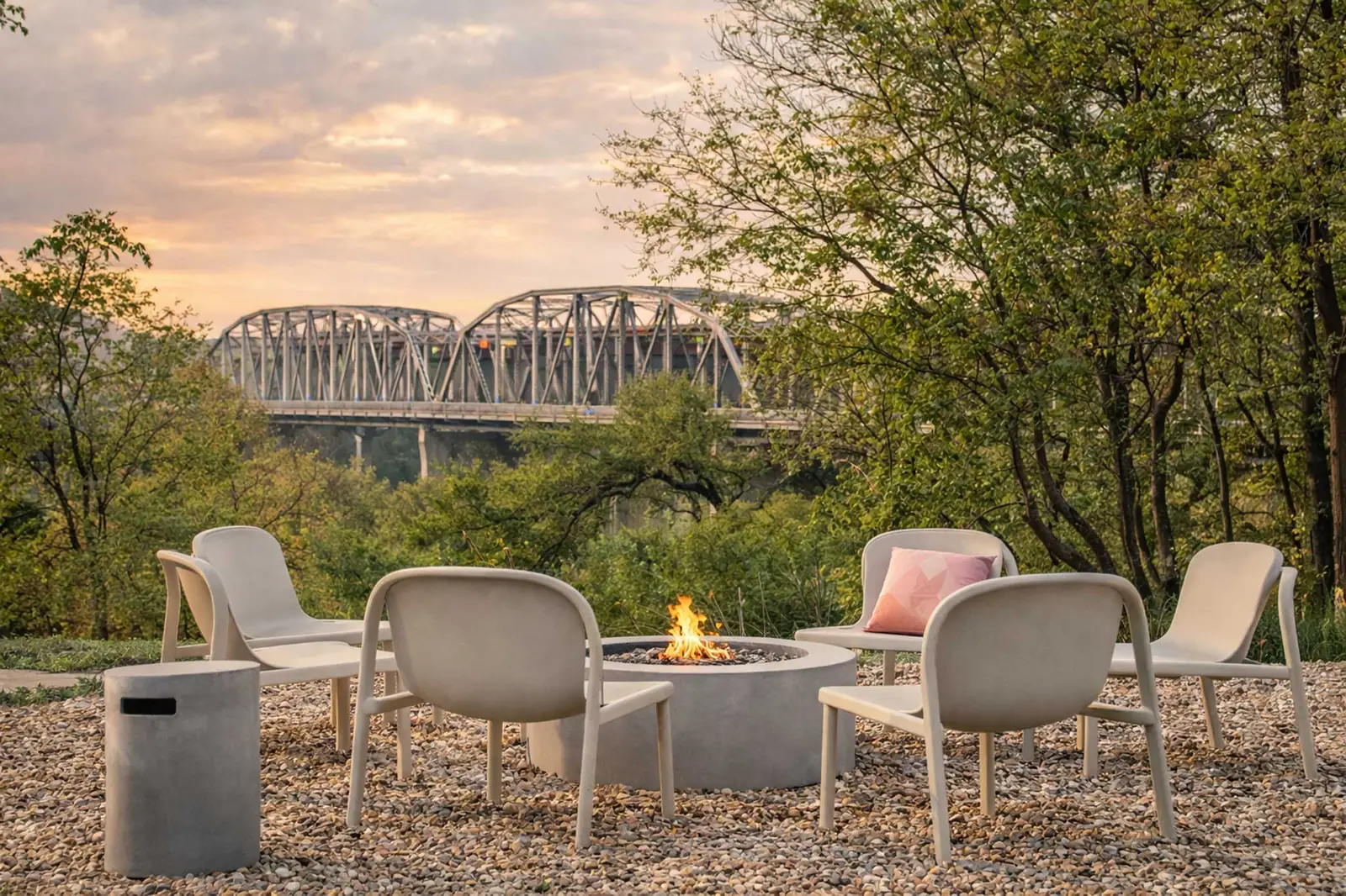 Bluff-side fire pit lounge overlooking the historic Montopolis Bridge, river, and skyline