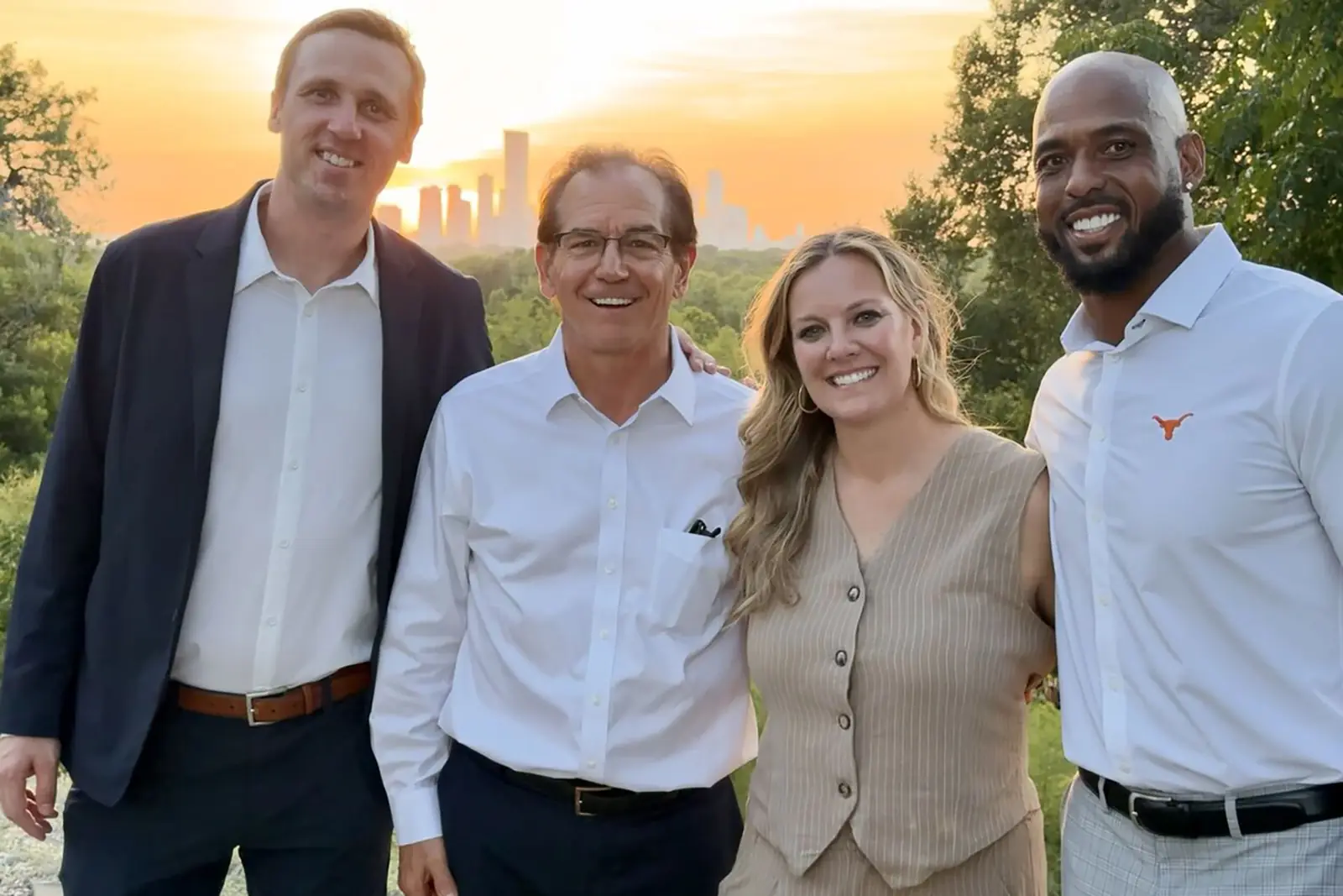 Four guests together on the bluff at sunset with the Austin skyline behind them